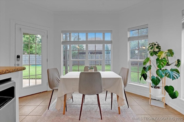 dining area with light tile patterned floors, plenty of natural light, and crown molding