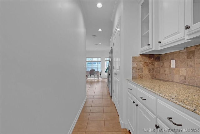 corridor featuring light tile patterned floors, baseboards, and recessed lighting