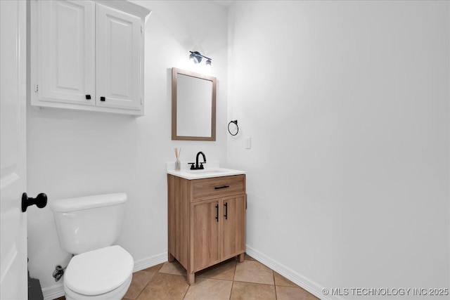 bathroom featuring baseboards, toilet, vanity, and tile patterned flooring