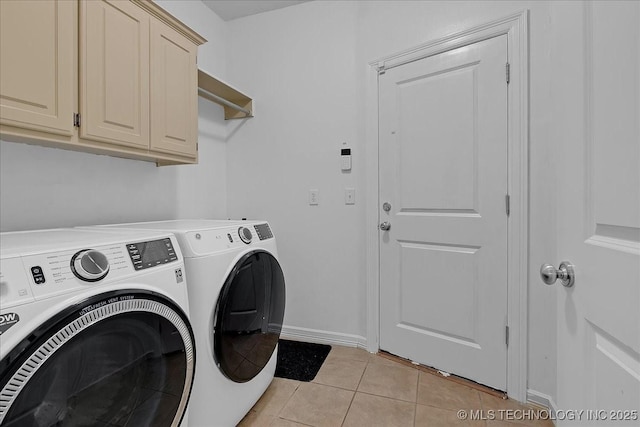 washroom featuring washing machine and dryer, light tile patterned floors, cabinet space, and baseboards