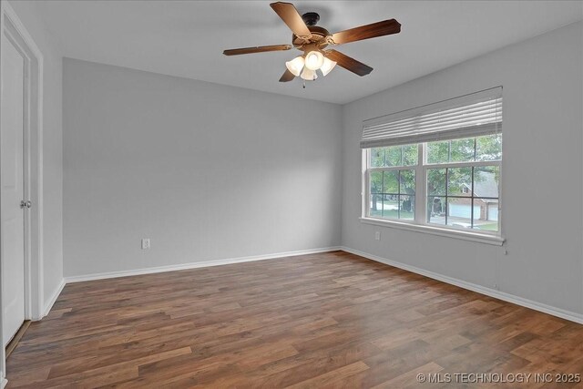 spare room featuring wood finished floors, ceiling fan, and baseboards