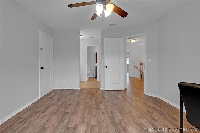 unfurnished bedroom featuring light wood finished floors, baseboards, and a ceiling fan