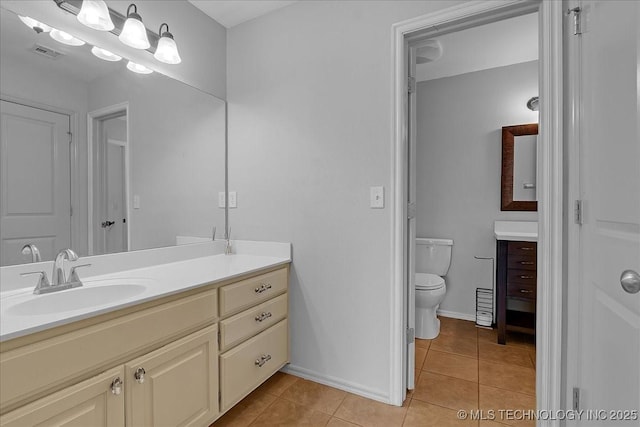 bathroom with tile patterned flooring, vanity, toilet, and baseboards