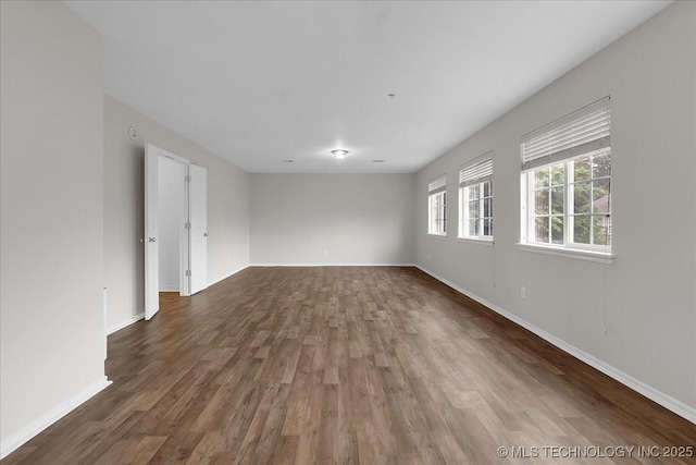 empty room featuring wood finished floors and baseboards