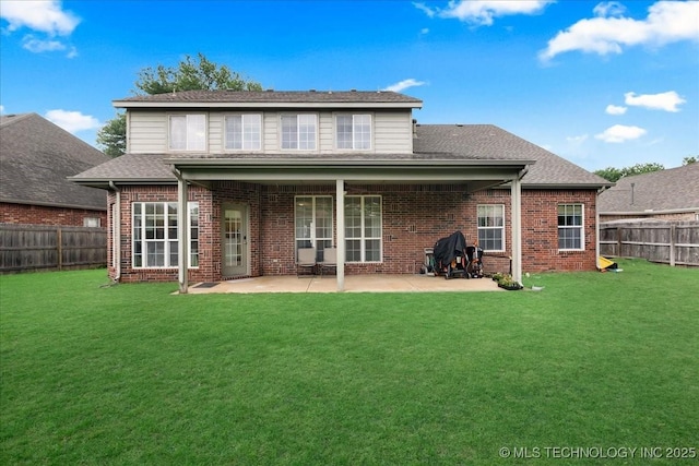 back of property with brick siding, a patio, and a shingled roof