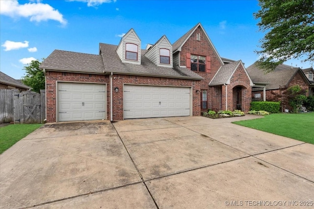 view of front of property with brick siding, driveway, a garage, a gate, and roof with shingles