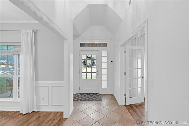 foyer entrance with crown molding and tile patterned floors