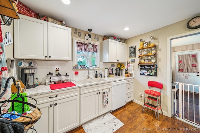 kitchen featuring dishwasher, a sink, dark wood-style flooring, light countertops, and recessed lighting