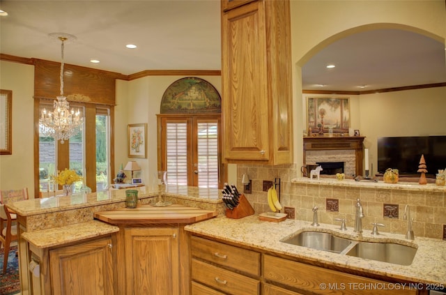 1310 N Northridge Ct, Sand Springs, OK 74063 - kitchen with a sink, a peninsula, decorative backsplash, arched walkways, and ornamental molding