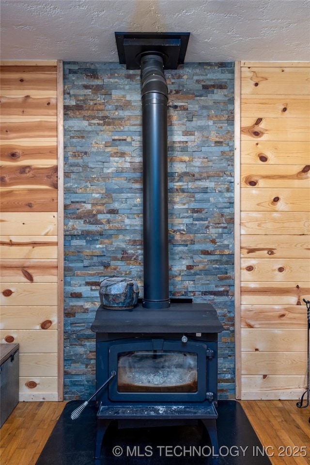 5700 S Wiley Rd, Milburn, OK 73450 - detailed view of a wood stove, wood finished floors, and a textured ceiling