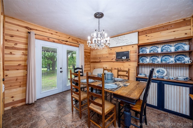 5700 S Wiley Rd, Milburn, OK 73450 - dining space featuring wood walls, a chandelier, dark stone finish floors, and french doors