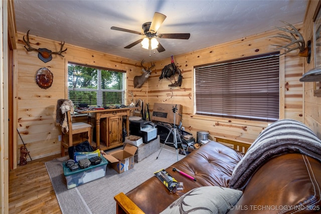 5700 S Wiley Rd, Milburn, OK 73450 - living room with wood walls, light wood finished floors, and ceiling fan