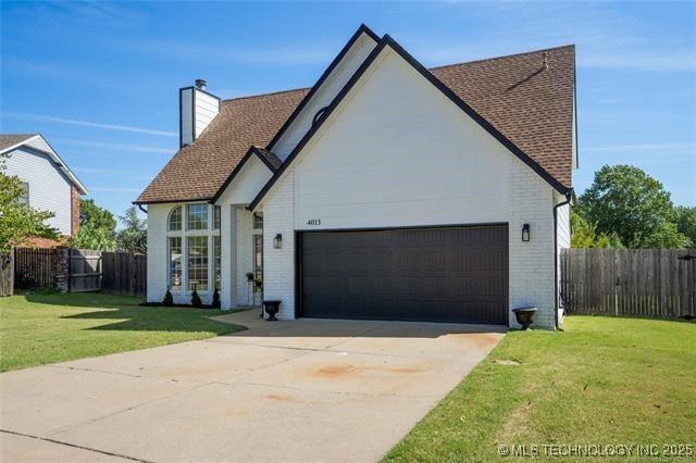 view of front of property featuring brick siding, an attached garage, driveway, a chimney, and a shingled roof