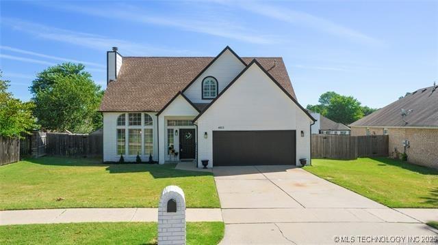 view of front of home with concrete driveway, a garage, and a chimney