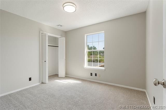 unfurnished bedroom featuring carpet, a closet, baseboards, and a textured ceiling