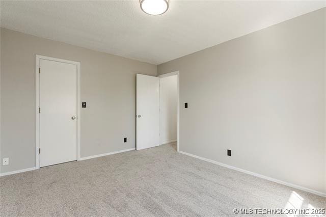 unfurnished bedroom featuring carpet floors and baseboards