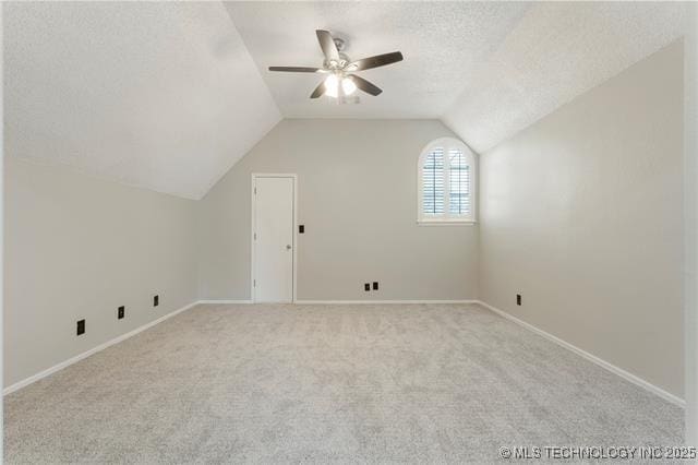 bonus room featuring ceiling fan, carpet floors, lofted ceiling, baseboards, and a textured ceiling