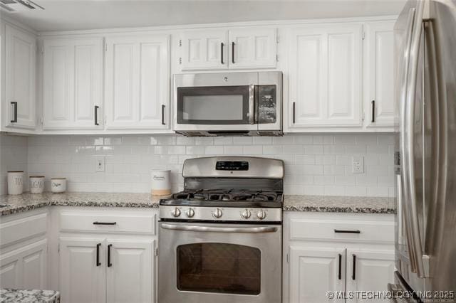 kitchen featuring stainless steel appliances, white cabinetry, and backsplash