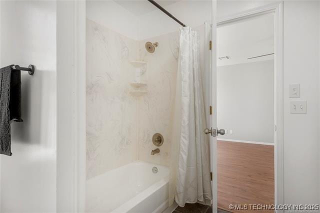 full bath with shower / bath combo with shower curtain, wood finished floors, and baseboards
