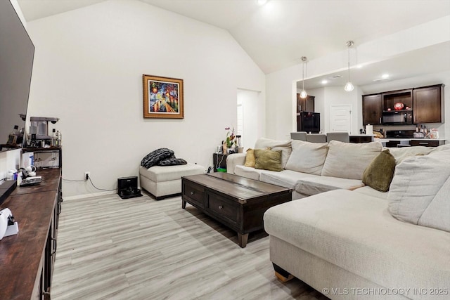 living room featuring vaulted ceiling and light wood-type flooring