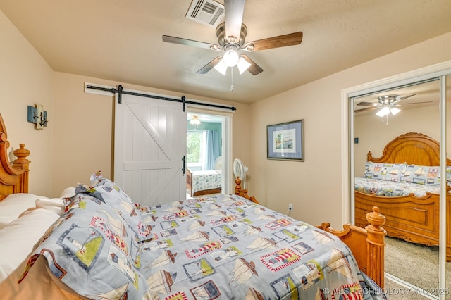 1694 Boat Ramp Rd, Kingston, OK 73439 - carpeted bedroom with a barn door, ceiling fan, and a closet