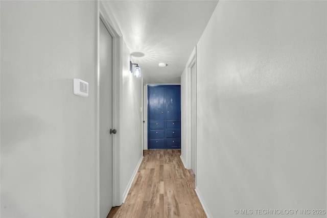 hallway featuring light wood-style floors and baseboards