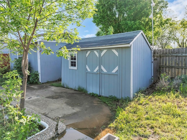 view of shed featuring fence