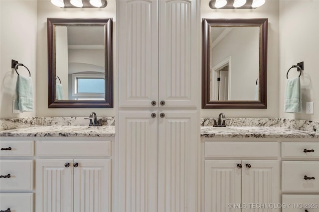 full bath with two vanities and crown molding
