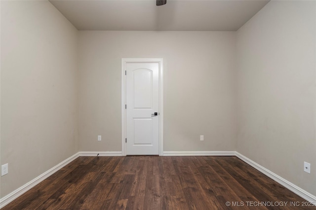 unfurnished room featuring dark wood-style floors and baseboards