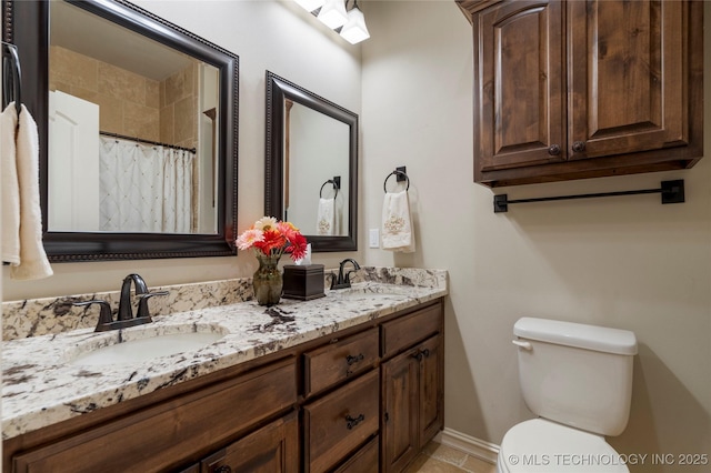 full bath featuring toilet, double vanity, baseboards, and curtained shower