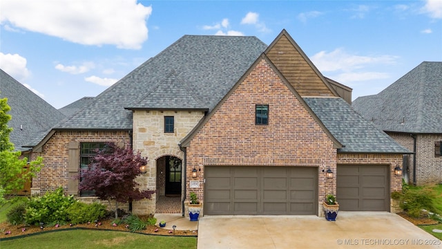 view of front of house with a shingled roof, brick siding, and stone siding