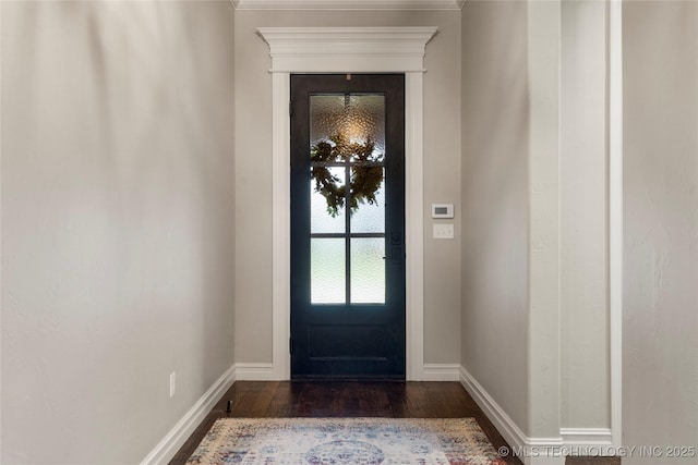 entryway featuring dark wood-style flooring, baseboards, and crown molding