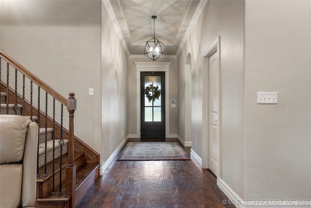 entrance foyer with wood finished floors, crown molding, stairway, and baseboards