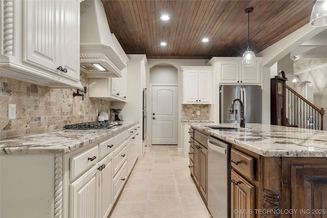 kitchen with appliances with stainless steel finishes, wooden ceiling, custom range hood, white cabinets, and light stone countertops