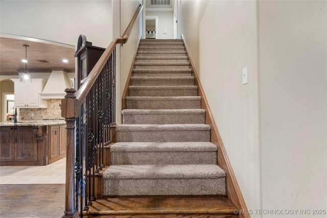 stairs with recessed lighting and arched walkways