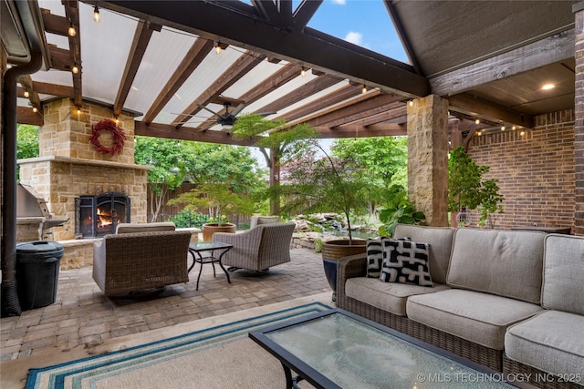 view of patio featuring an outdoor living space with a fireplace and a ceiling fan