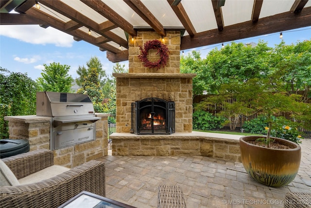view of patio with an outdoor stone fireplace and area for grilling