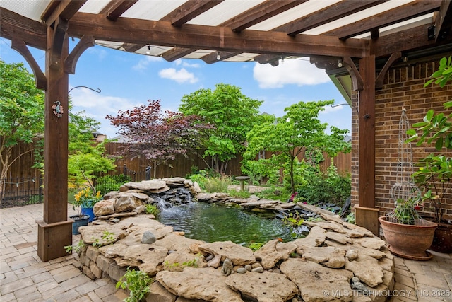 view of yard with a small pond, fence, and a pergola