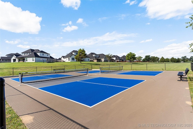 view of tennis court with a residential view