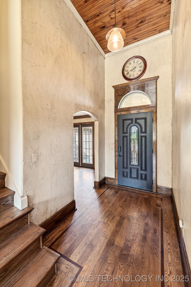 entryway with arched walkways, wood ceiling, stairs, dark wood-style floors, and crown molding