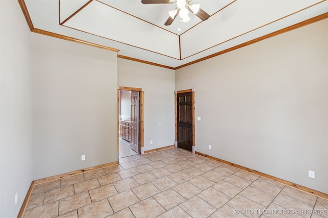 spare room with a ceiling fan, light tile patterned floors, baseboards, crown molding, and a towering ceiling