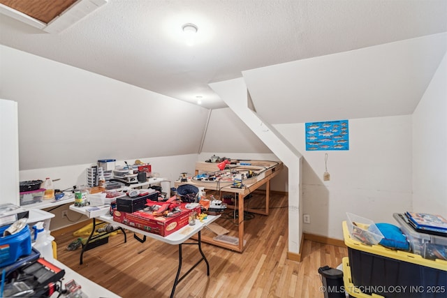 playroom with light wood-style floors, lofted ceiling, and baseboards