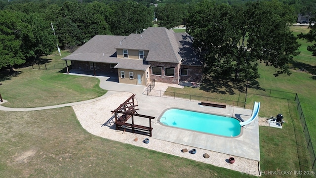 view of swimming pool with a water slide and a patio
