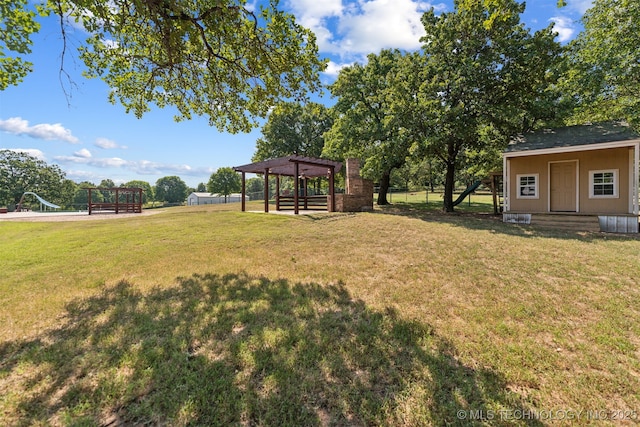 view of yard with a pergola and an outdoor structure