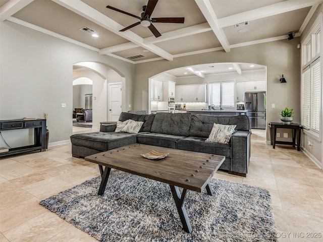 3661 S Lewis Ave, Tulsa, OK 74105 - living room featuring a ceiling fan, light tile patterned floors, coffered ceiling, beamed ceiling, and arched walkways