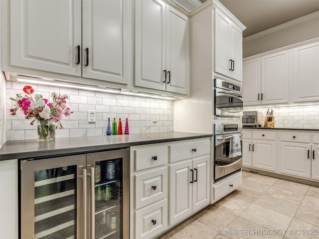 3661 S Lewis Ave, Tulsa, OK 74105 - kitchen with beverage cooler, dark countertops, ornamental molding, backsplash, and white cabinets