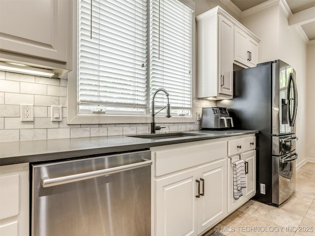 3661 S Lewis Ave, Tulsa, OK 74105 - kitchen with appliances with stainless steel finishes, dark countertops, crown molding, backsplash, and white cabinetry