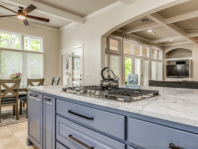 3661 S Lewis Ave, Tulsa, OK 74105 - kitchen featuring stainless steel gas stovetop, gray cabinets, arched walkways, beam ceiling, and light stone counters
