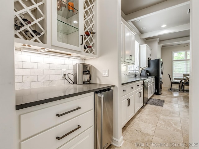 3661 S Lewis Ave, Tulsa, OK 74105 - kitchen with dark countertops, stainless steel appliances, decorative backsplash, glass insert cabinets, and recessed lighting