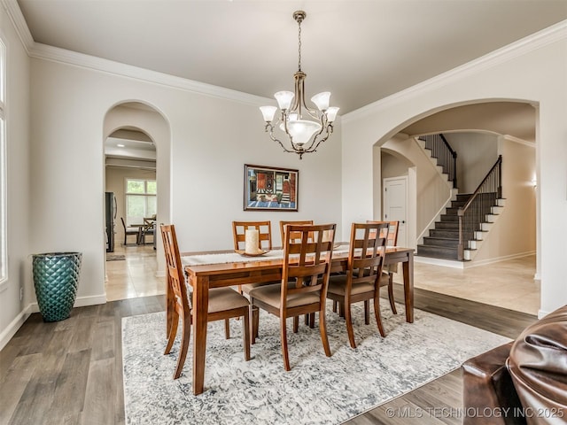 3661 S Lewis Ave, Tulsa, OK 74105 - dining area featuring ornamental molding, arched walkways, wood finished floors, a chandelier, and baseboards